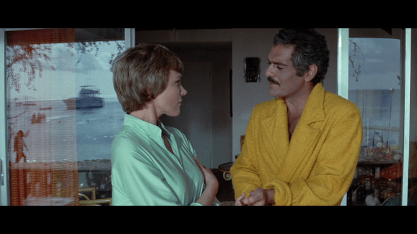 Screengrab from The Tamarind Seed showing Julie Andrews and Omar Sharif shot through a window that two boats are reflected in