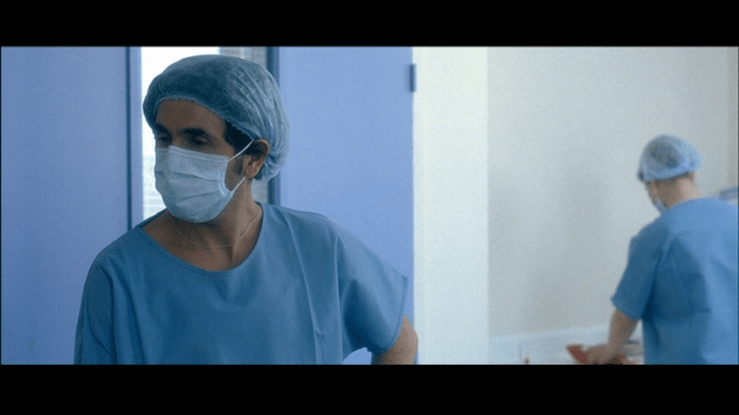 Screengrab from A Christmas Tale showing Doctor Zraïdi wearing a surgical mask