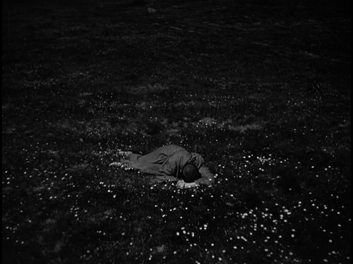 Screengrab from The Flowers of St. Francis showing Francis lying in a field