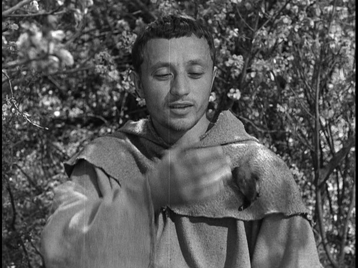 Screengrab from The Flowers of St. Francis showing Francis dropping the bird he is reaching for