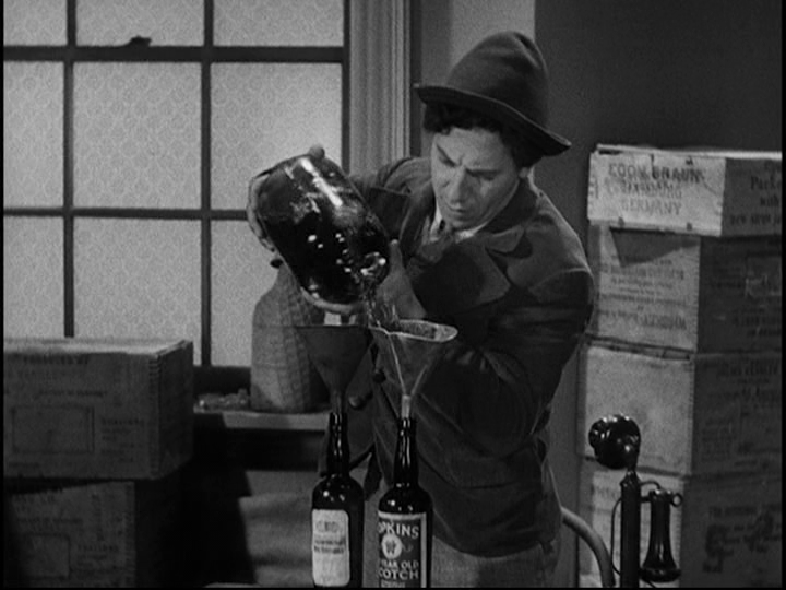 Screengrab from Horse Feathers showing Baravelli filling orders for two different kinds of liquor from the same bottle