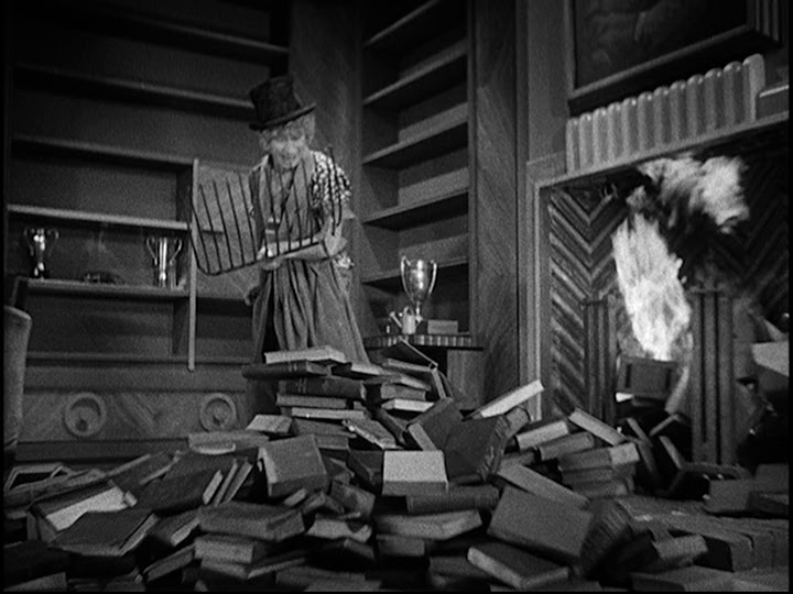 Screengrab from Horse Feathers showing Pinky shoveling books into a fire