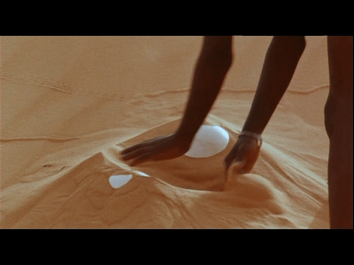 Screengrab from Yeelen showing Nianankoro's son finding two ostrich eggs in the sand.