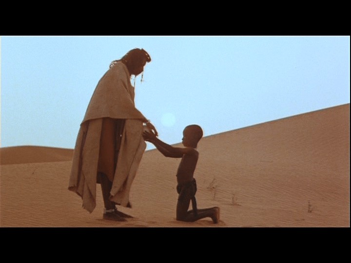 Screengrab from Yeelen showing Nianankoro's son presenting an ostrich egg to his mother.