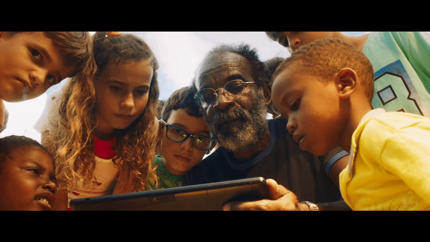 Plinio and his students huddled over a tablet computer