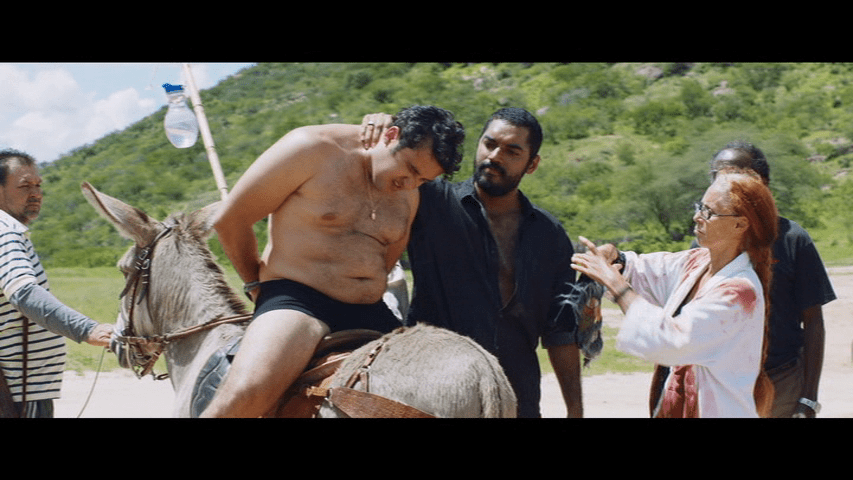 Medium shot of a naked Tony Jr. being run out of town on a donkey