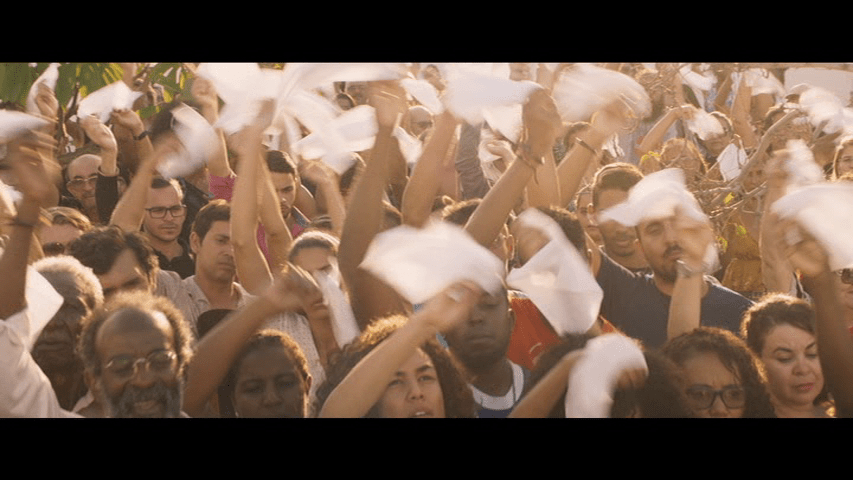 Funeral attendees waving white handkerchiefs