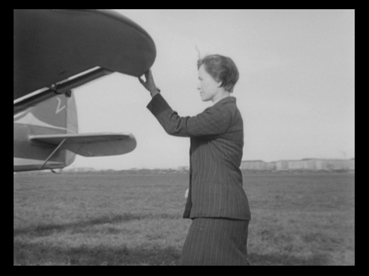 Petrukhina seeks shelter from the rain under the wing of a plane