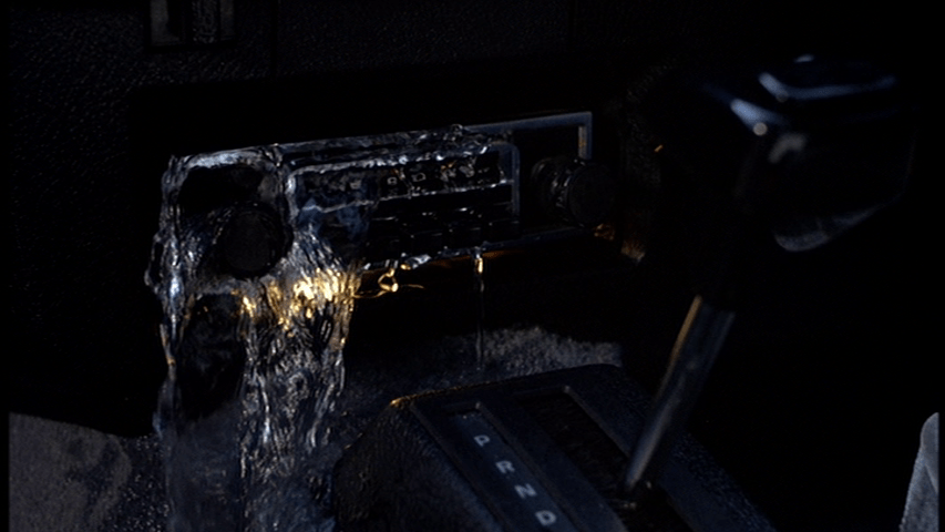 Close-up of water pouring into David's car through the radio