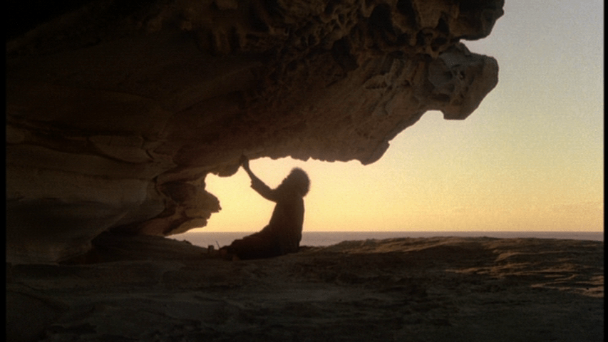 Charlie painting signs on a rock outcropping
