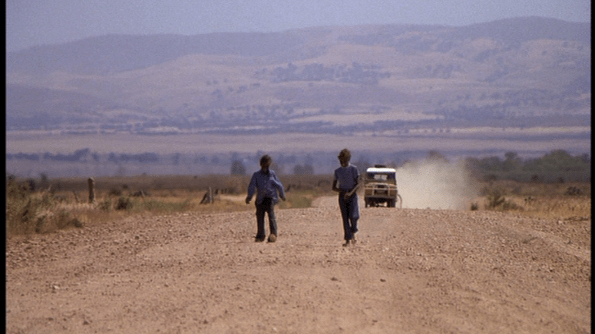 Two Aboriginal children on a dusty road