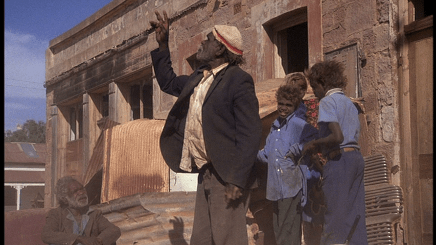 An Aboriginal man gestures at the sky