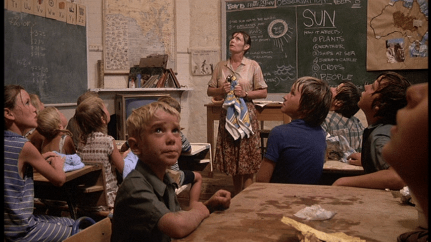 A teacher and her students listen to hail on the roof of their school