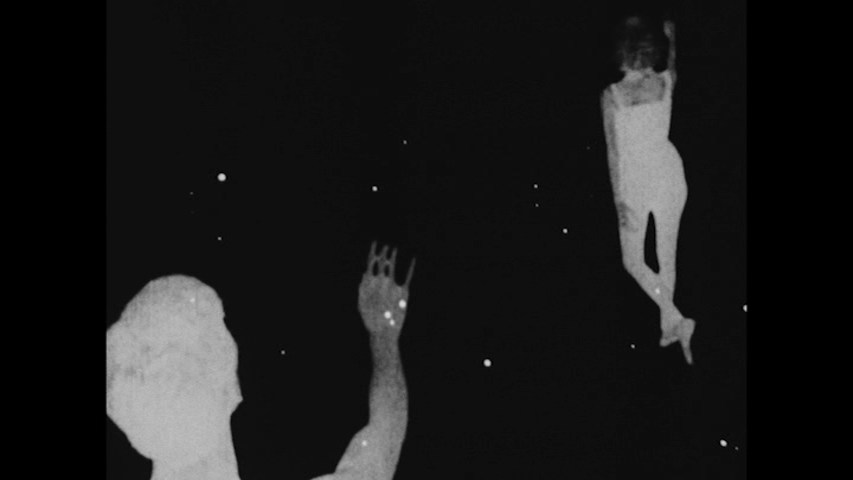 A male dancer gestures at a woman dancer with her back to him