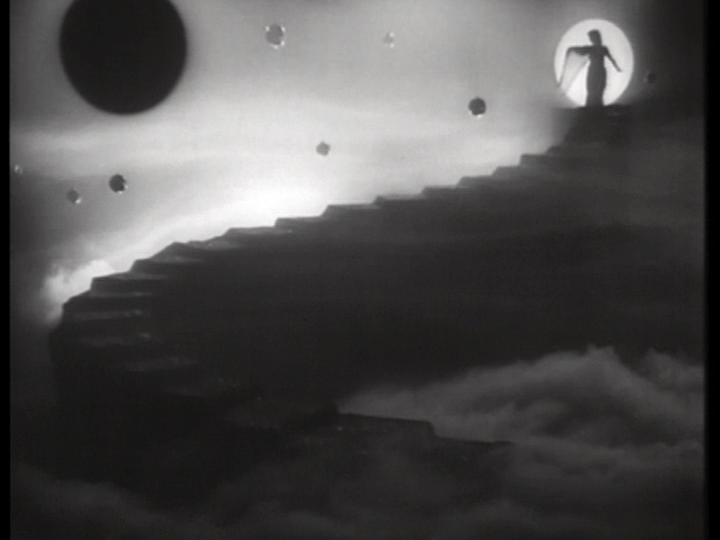 A silhouetted figure descends a winding stairway shrouded in fog