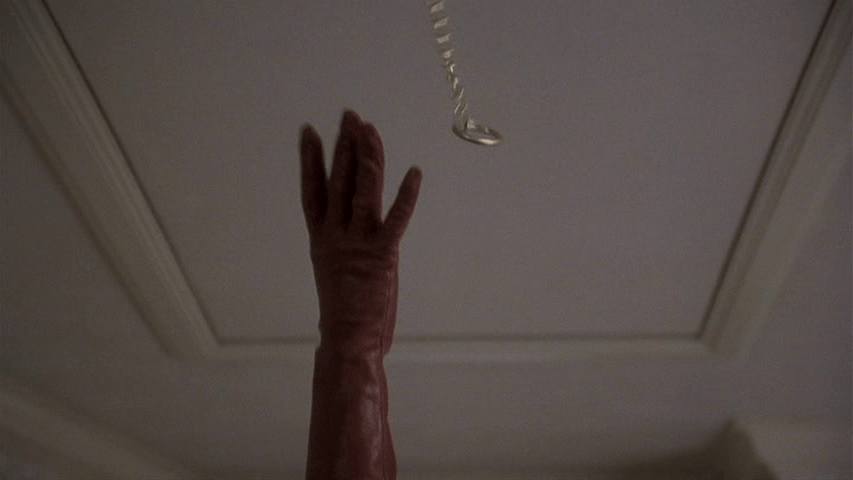 Close-up of a gloved hand grasping at a chain