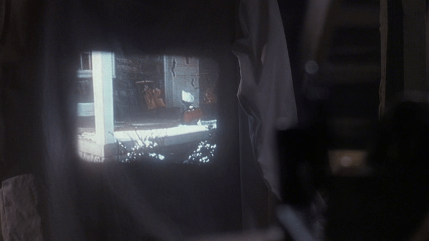 POV shot of home movies being projected on a makeshift screen constructed out of a sheet