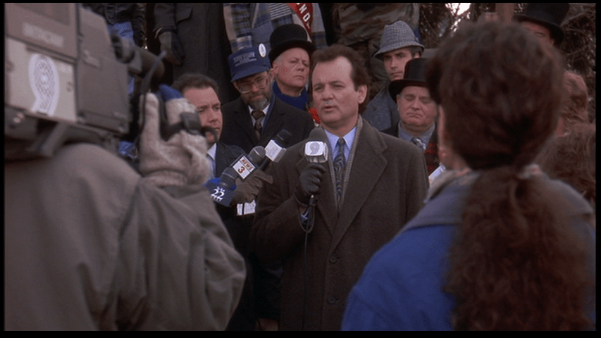 Medium shot of Phil Connors reporting living from Punxsutawney