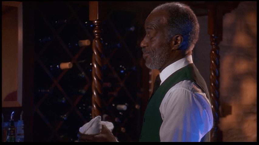 Medium shot of John Watson Sr.'s bartender smirking