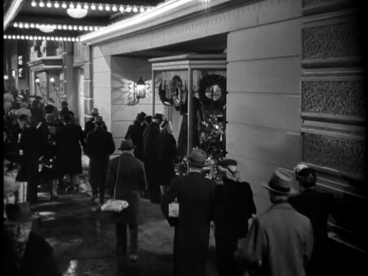 Long shot of Chris walking down a crowded street