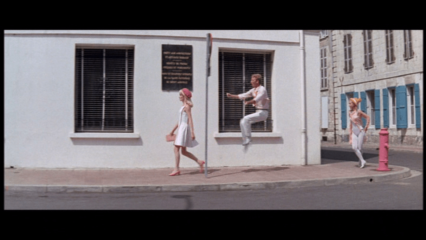 Delphine walks down the street as pedestrians dance all around her