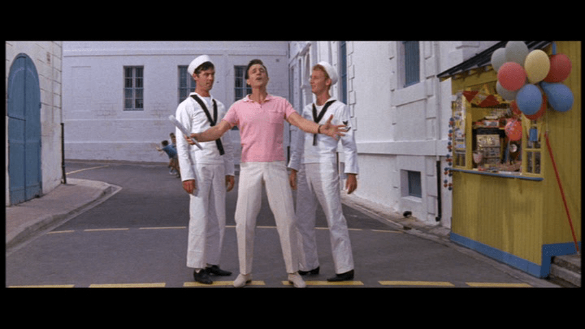 Gene Kelly preparing to tap dance with two sailors