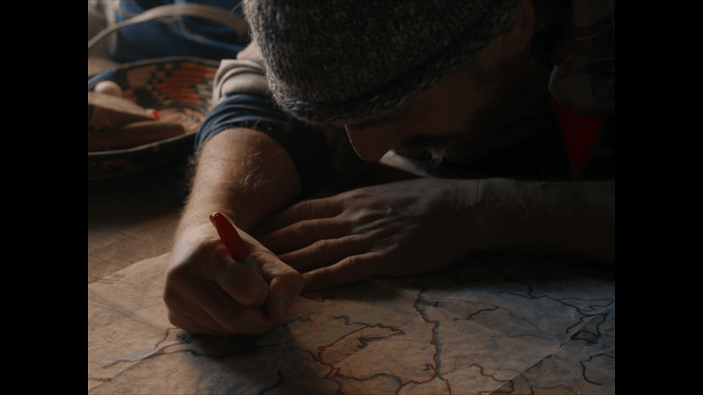 Pietro marks a climb on his father's map