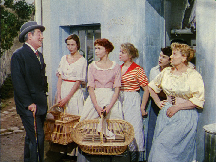 Danglard discusses Nini's wages with her mother as her sisters and a friend look on