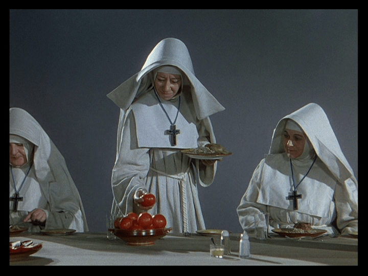 Medium shot of Sister Philippa inspecting a tomato