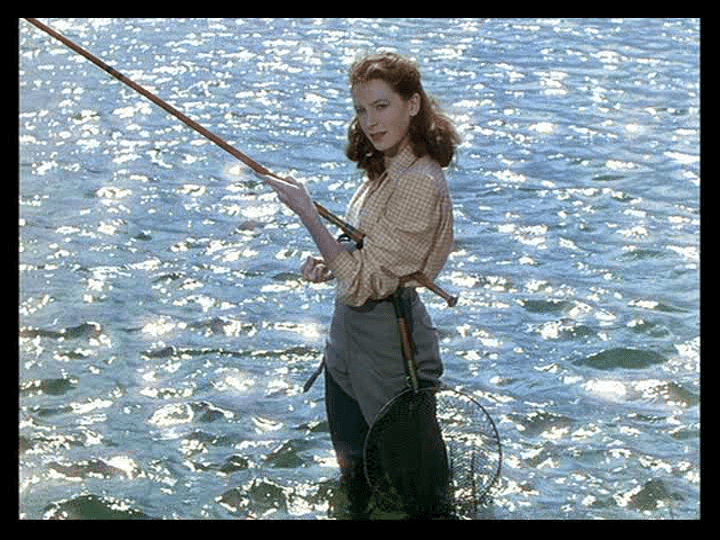 Medium shot of a young Clodagh fishing while sun flashes on the waves