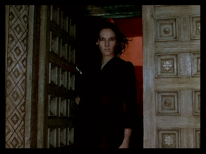 A demonic-looking Sister Ruth stands in one of Mopu's doorways