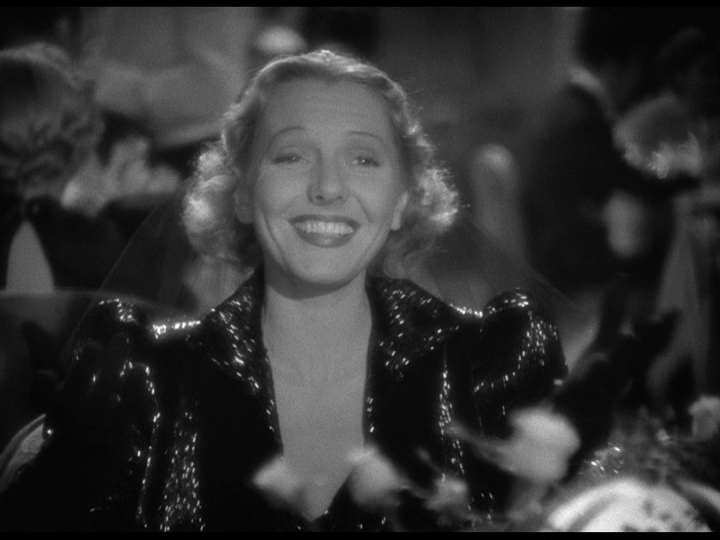 Medium shot of Irene in a shimmery black dress