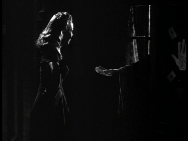 A fortune teller holds out a deck of cards to Clo-Clo