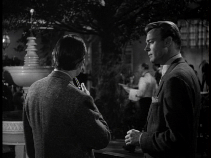 Galbraith gestures at a fountain with his pipe