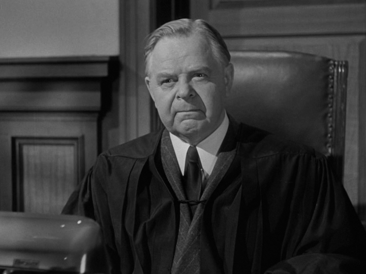 A worried Judge Harper looks across the courtroom at his political advisor...