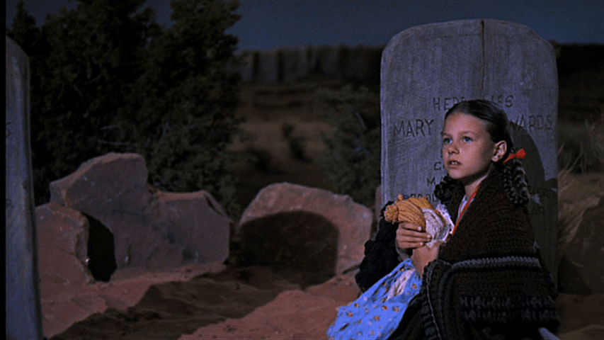 Debbie sits in front of her grandmother's tombstone