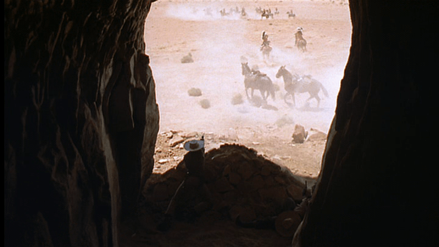 Ethan and Marty shooting at Scar's band from inside a cave