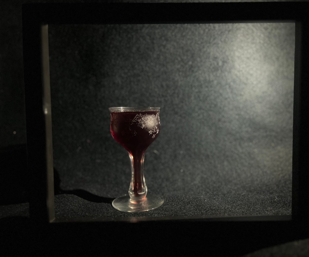 Nouveau Sangaree in a cocktail glass inside a frame that evokes the Schneller scene from the movie Playtime
