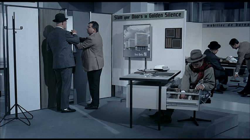 A "false" Hulot rifles through files at a booth for a German company with the slogan, "Slam your Doors in Golden Silence"