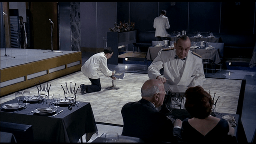 The labor of building and cooking is connected via the gestures of two waiters