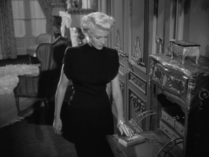 Medium shot of Elsa pushing a button on an intercom