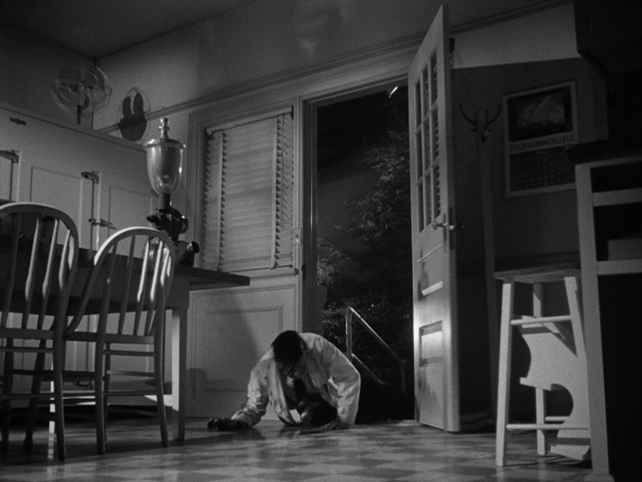 Long shot of a man who has been shot bursting through a door
