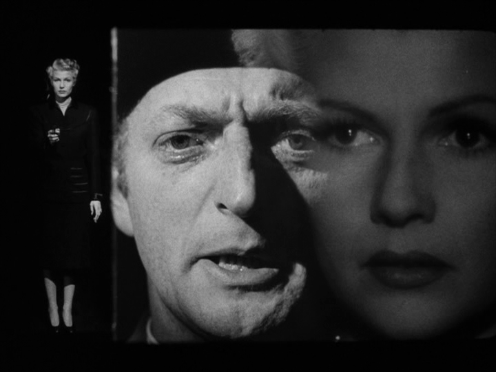 Another split screen shot with Elsa still pointing a gun at Arthur on the left, a close-up of Arthur's face in the middle, and a close-up of Elsa's face on the right