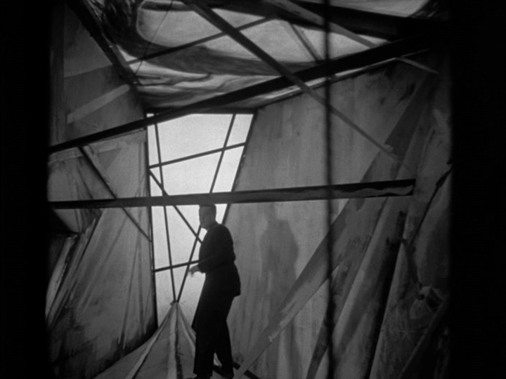 Michael walks through a German Expressionism-style hallway with weirdly shaped doors