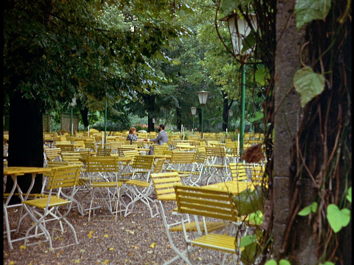 Extreme long shot of Ali and Emmi in a sea of yellow tables