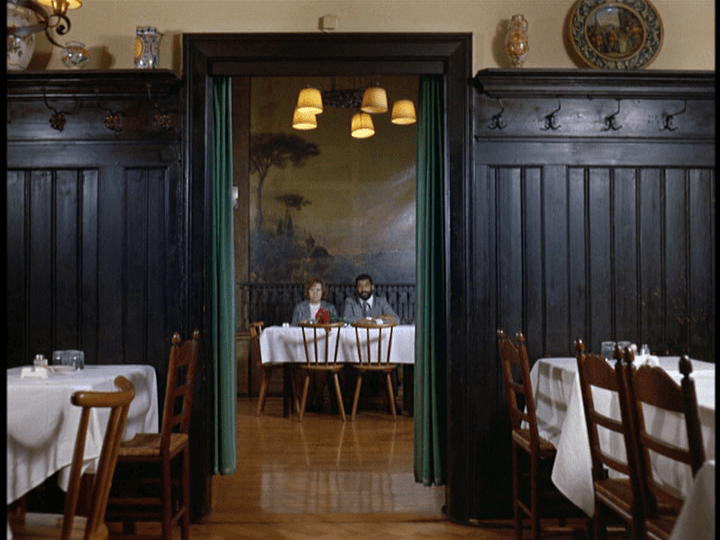 Ali and Emmi at a restaurant, framed in a doorway