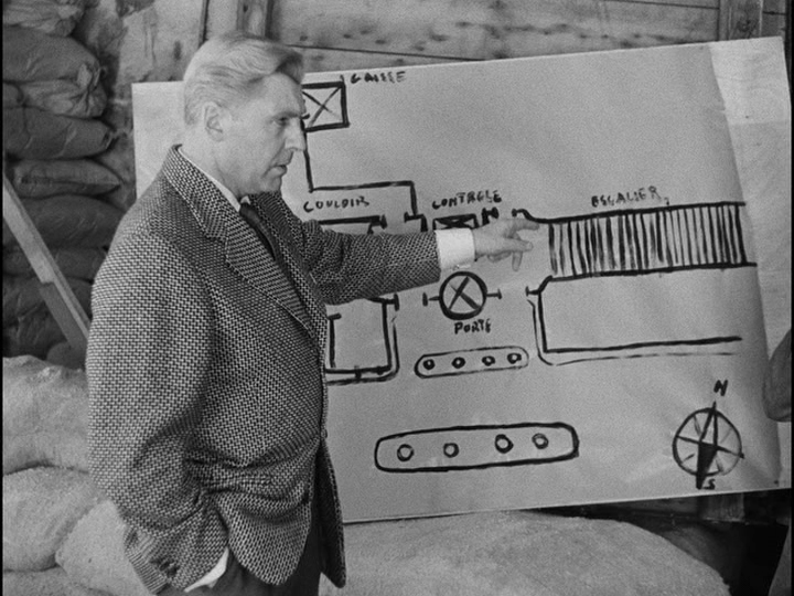 Medium shot of Bob gesturing at a floor plan