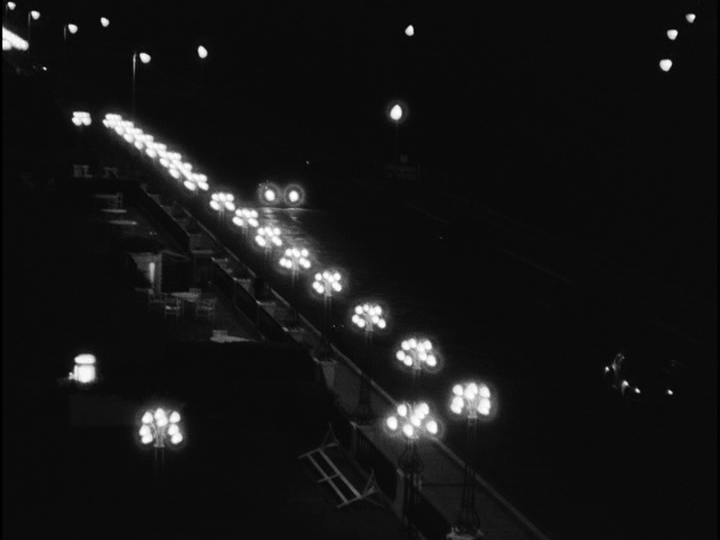 Long shot of blurry car headlights next to blurry streetlights that look like flowers