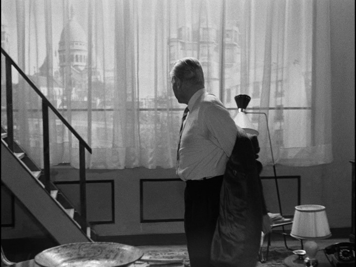 Bob standing in front of a giant window with a great view of Paris