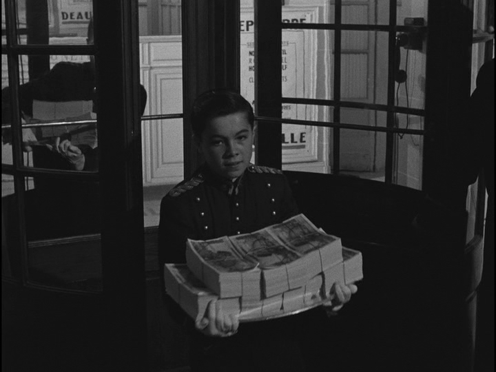 Medium shot of a bellhop holding a tray of cash